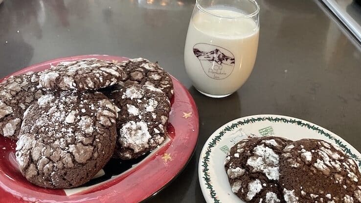 Chocolate Crinkle Cookies on two plates and a small glass of milk