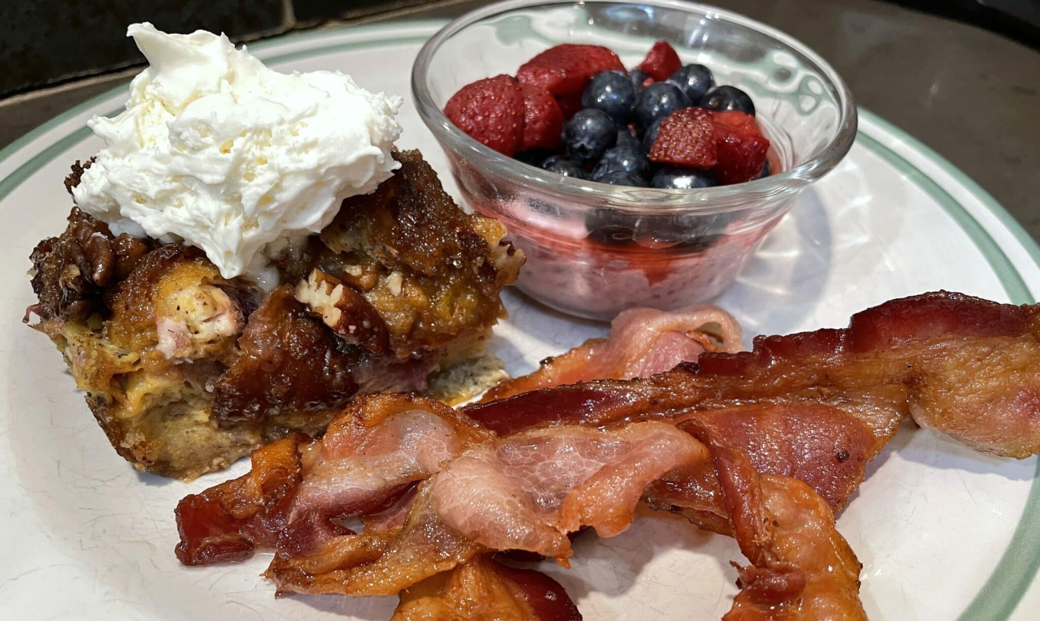 Blueberry Croissant French Toast with whipped cream, bacon and fresh berries