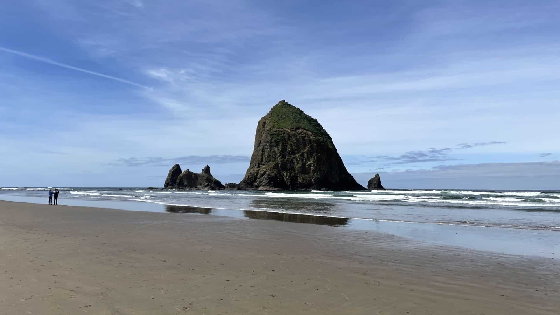 Haystack Rock at Cannon Beach along a sandy beach