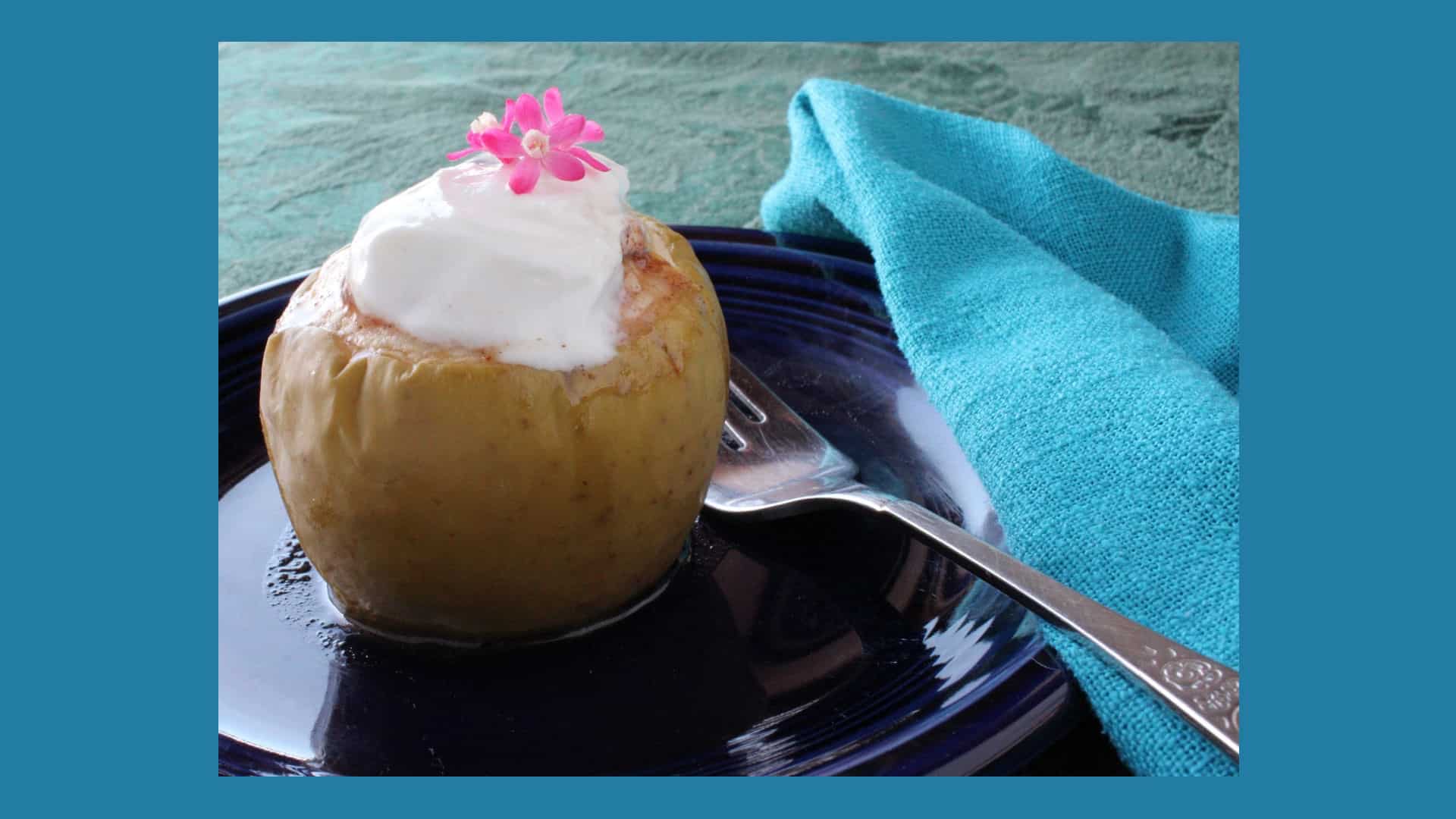 Crusted Apple Pie on a dark plate with fork and blue napkin