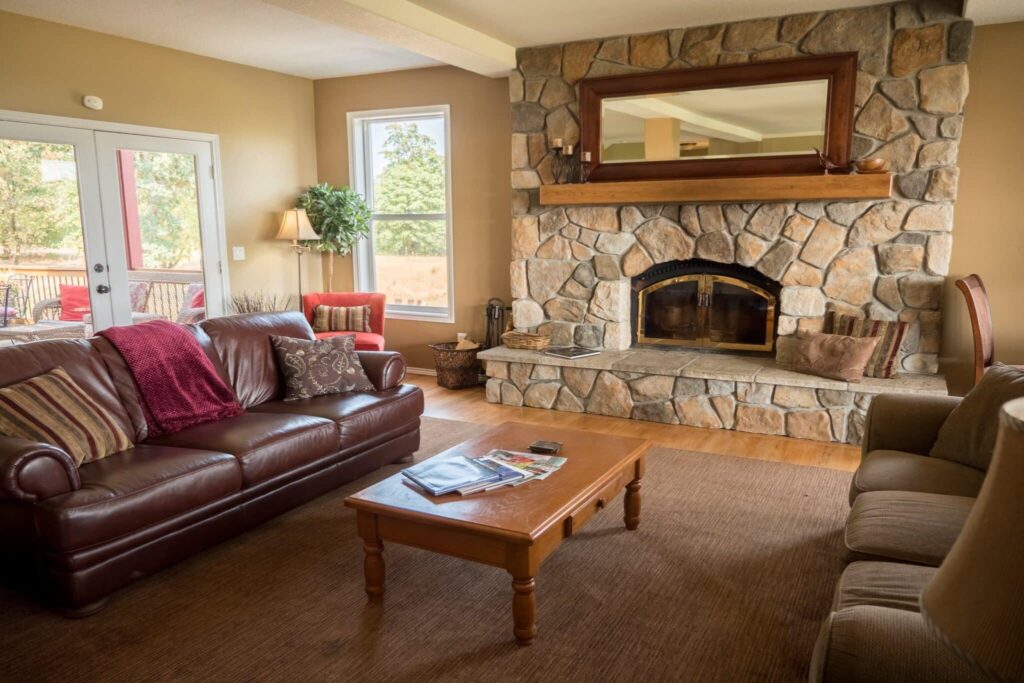 The DreamGivers inn common room with couches and a massive rock fireplace