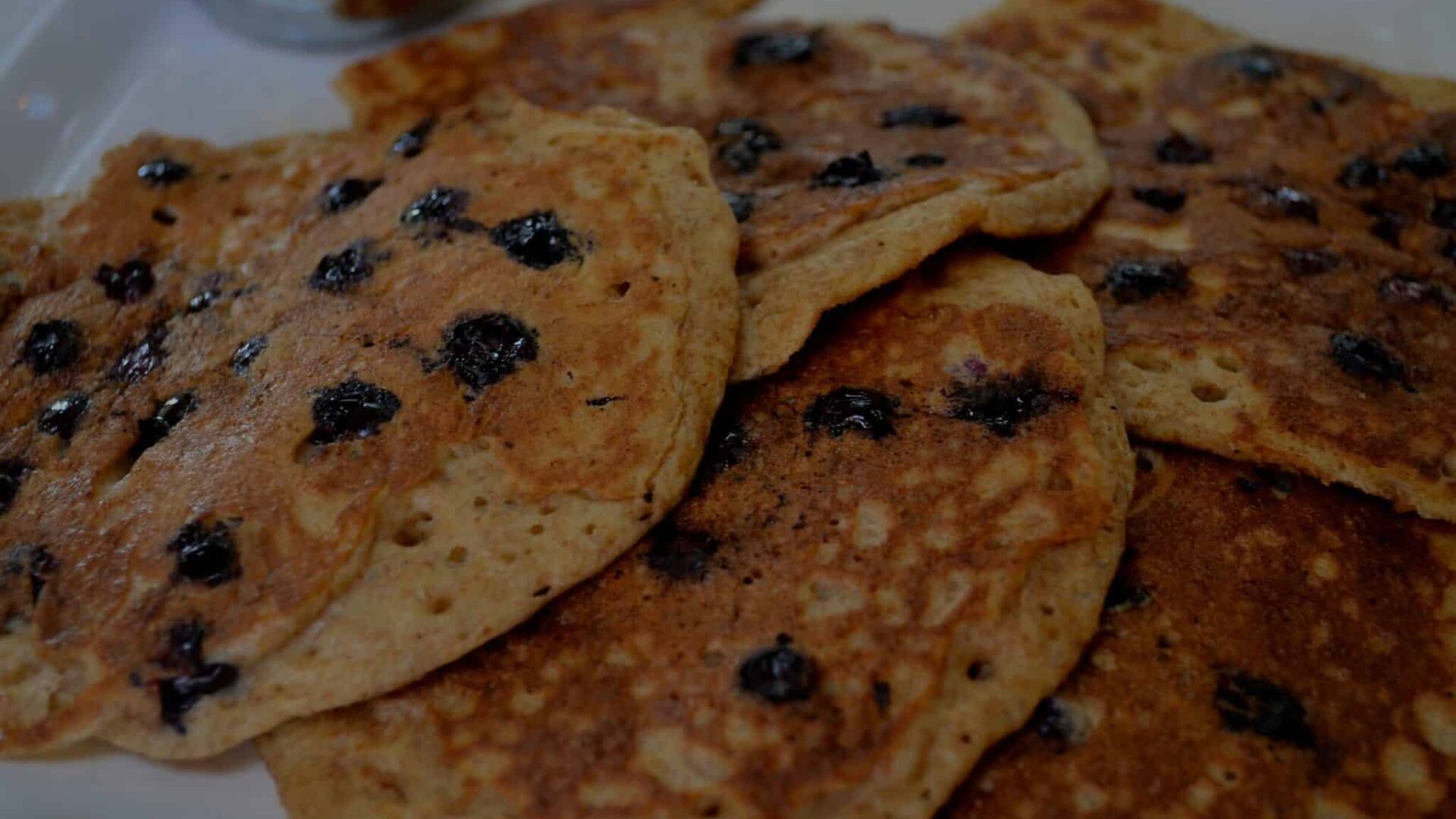 a stack of Blueberry Pancakes on a white plate