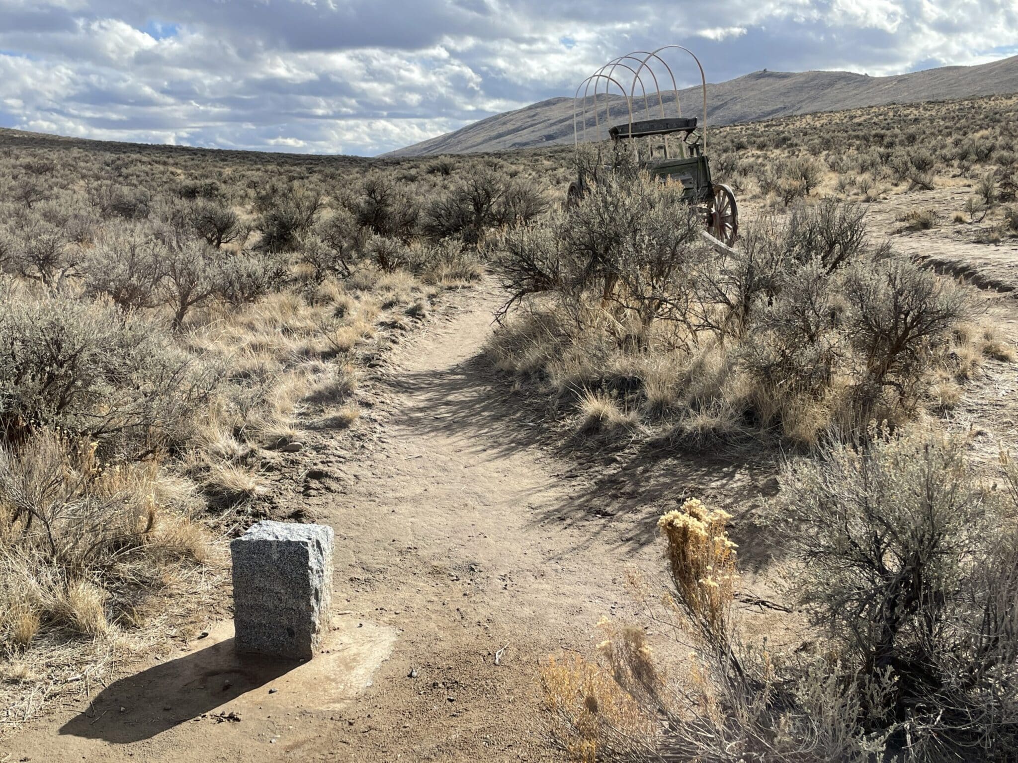 Historic Oregon Trail marker in the sage with an abandoned wagon