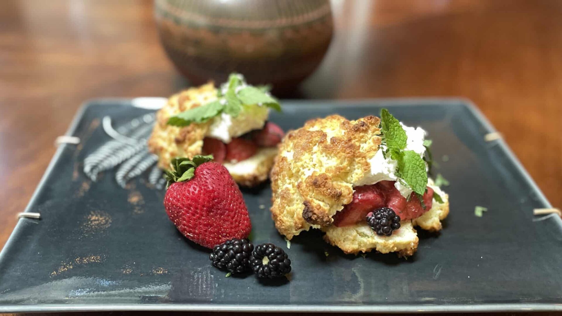 Two Strawberry Shortcakes on a dark green platter