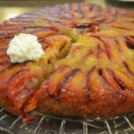 Plum upside down cake on a glass serving platter