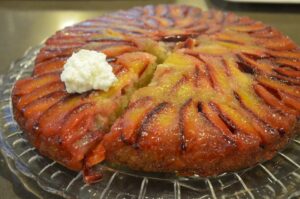 Plum upside down cake on a glass serving platter