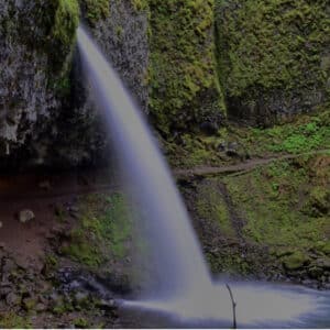 Horsetail Creek shoots through a narrow crack into a large pool in front of a deep recess, which allows a trail to pass behind Pony Tail