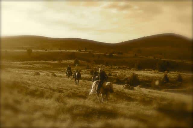 horseback riders rider the open prairie - sepia filter