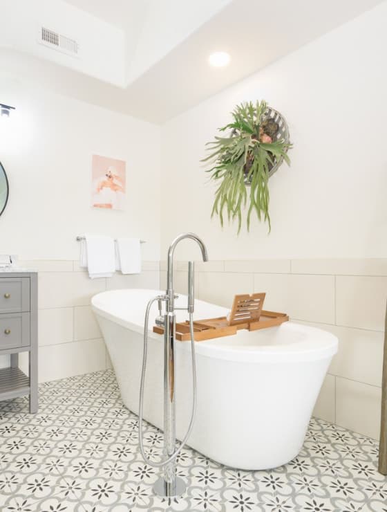 Bathroom with white walls, tiled flooring, and large white tub